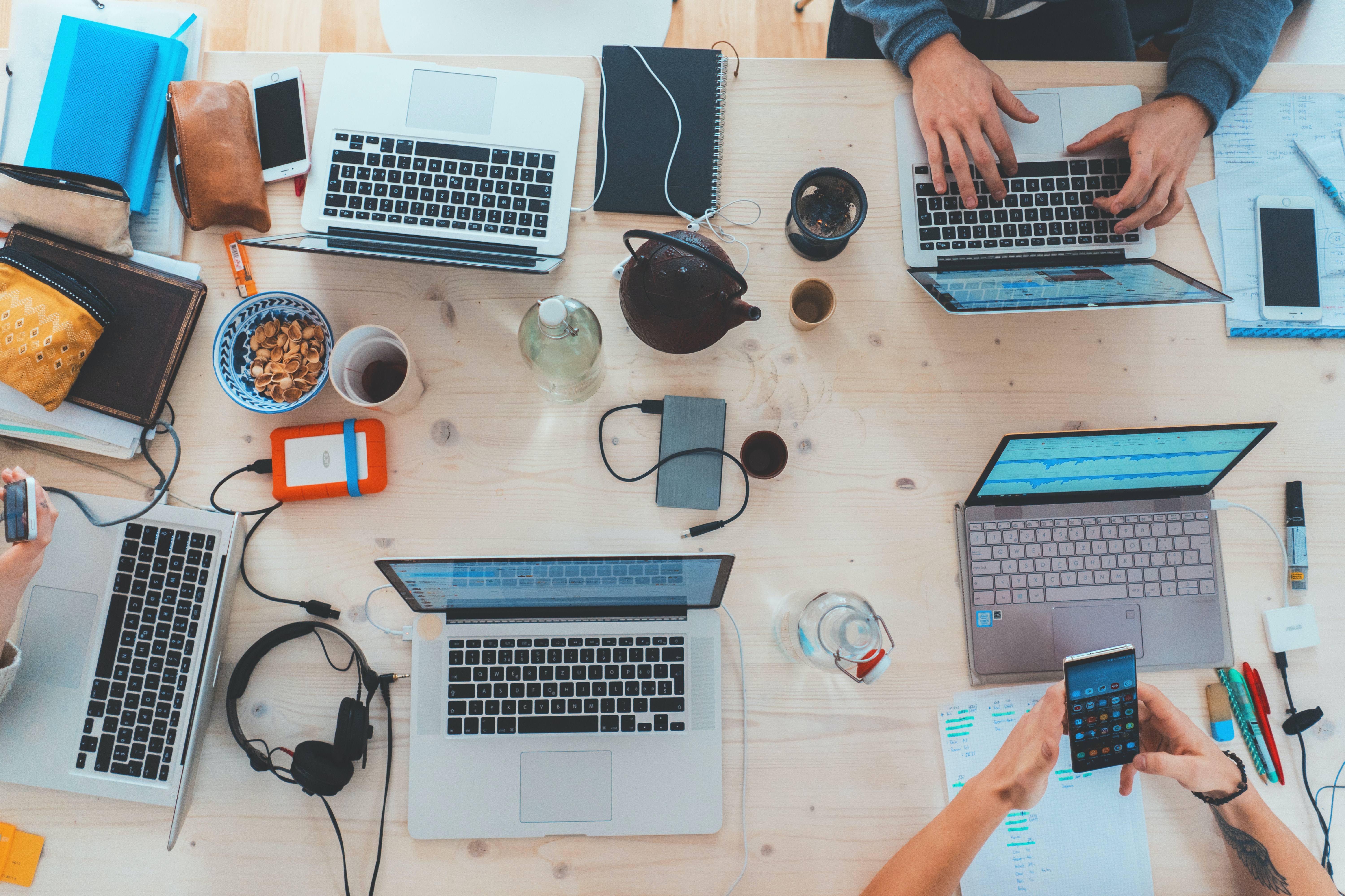 a huddle of laptops around a table 